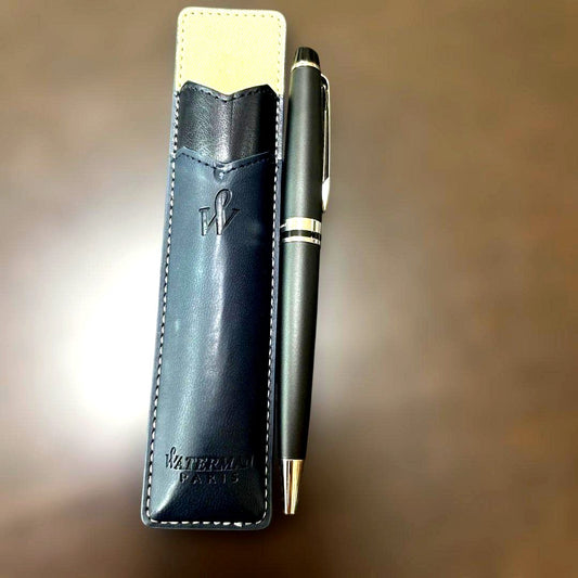 Used Waterman black ballpoint pen with a leather case showing a dent