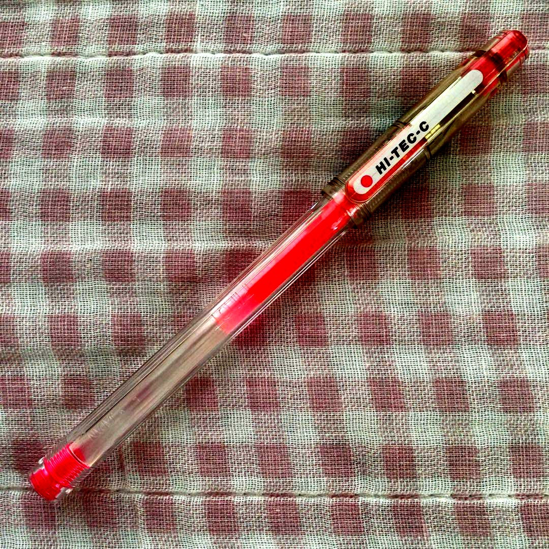 Pilot Hi-Tec C ballpoint pen in fluorescent pink with ink visible, discontinued edition