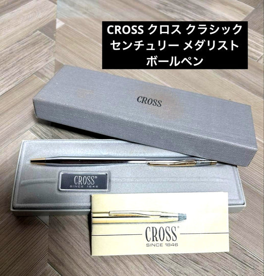 CROSS Classic Century Medalist ballpoint pen in silver with gold accents beside its presentation box