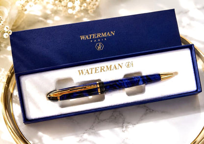 WATERMAN ballpoint pen with deep blue marble body and gold trim shown uncapped with blue ink tip