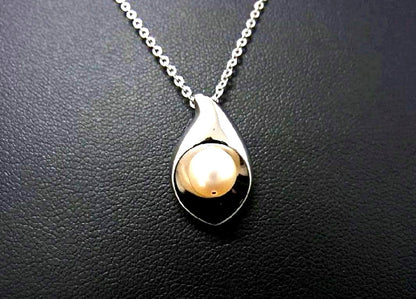Tasaki pearl necklace with 6mm pearls and 16-inch length displayed on a white background