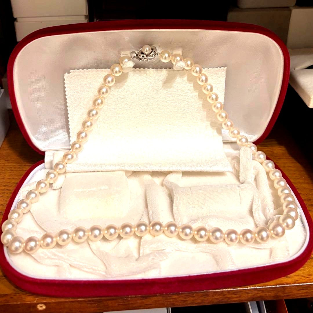 Tasaki Akoya pearl necklace with 8mm pearls and silver fittings laid out flat