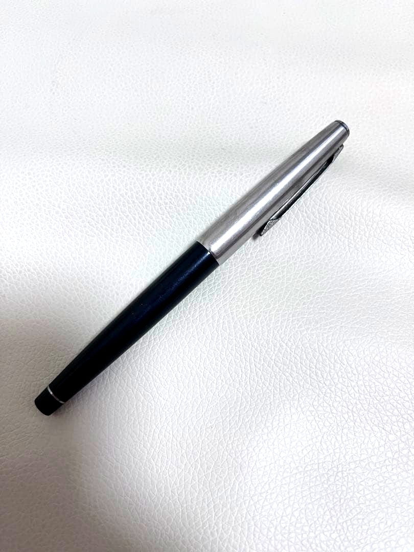 14K pen tip PILOT fountain pen with black and silver body and inset nib on white background