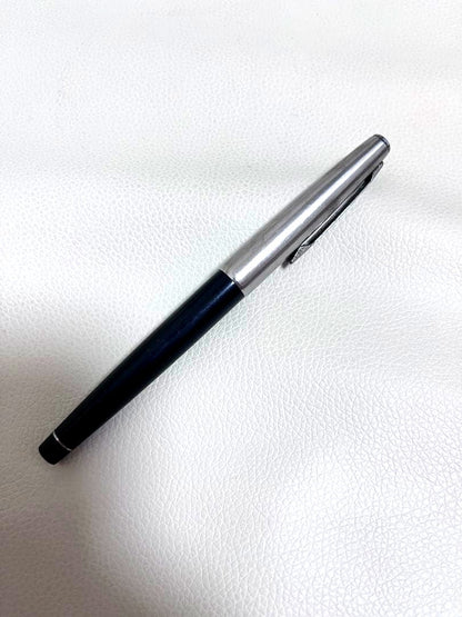 14K pen tip PILOT fountain pen with black and silver body and inset nib on white background
