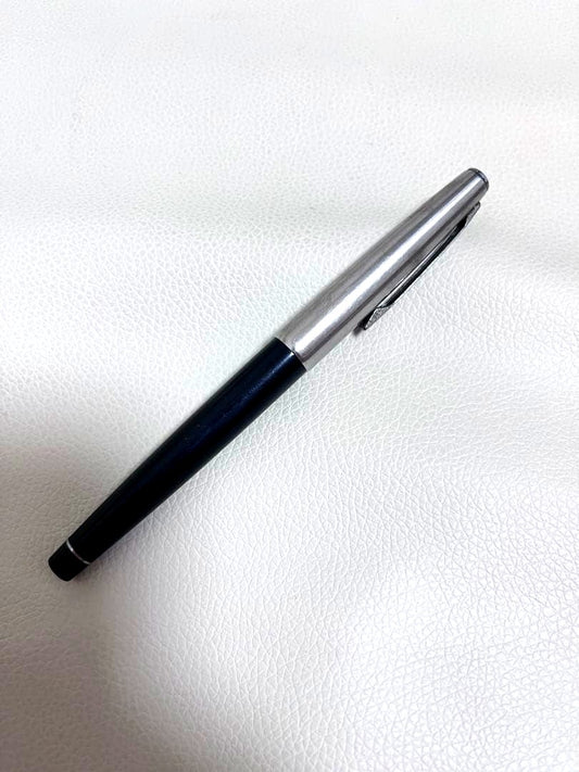 14K pen tip PILOT fountain pen with black and silver body and inset nib on white background