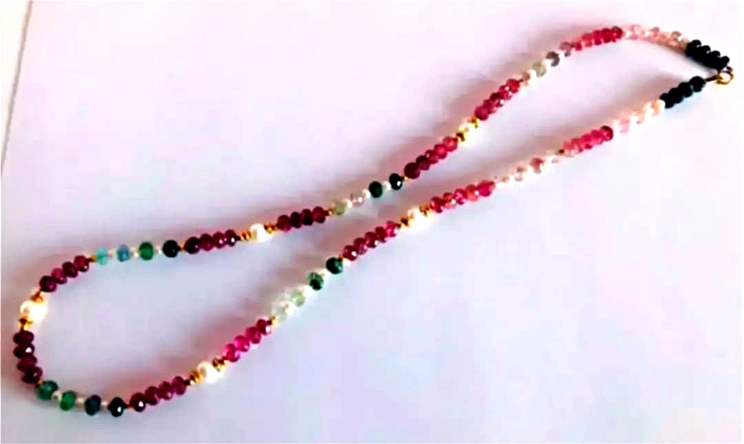 K18 gold necklace with 31 Akoya pearls and mixed cut tourmaline gemstones on display
