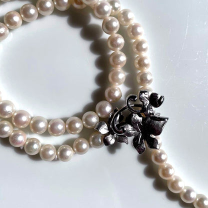 Akoya pearl necklace with 6mm white pearls and silver clasp showing pink and green interference colors