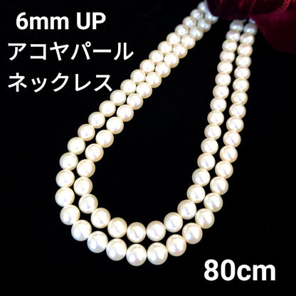 Akoya pearl necklace with 6mm pearls, 80cm length, silver clasp laid flat on white background
