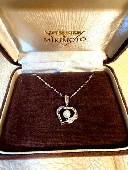 MIKIMOTO heart-shaped pearl necklace with silver pendant on white background