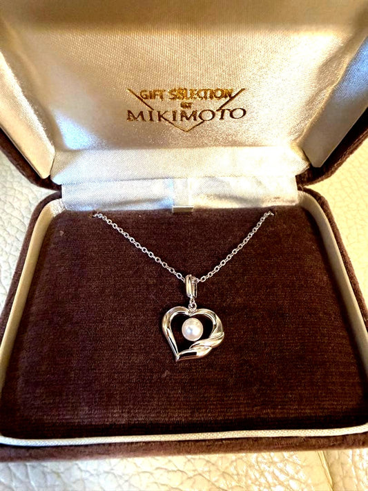 MIKIMOTO heart-shaped pearl necklace with silver pendant on white background