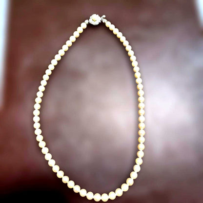 Akoya pearl necklace featuring lustrous pearls and a pearl decorated matte silver insertion clasp
