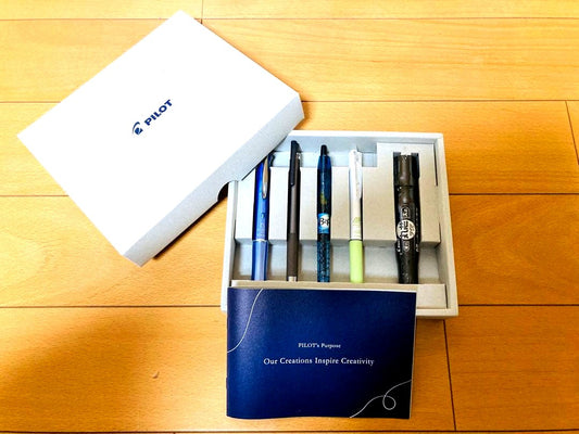 Five-piece set of Pilot pens including leaflet for each writing instrument on a white background