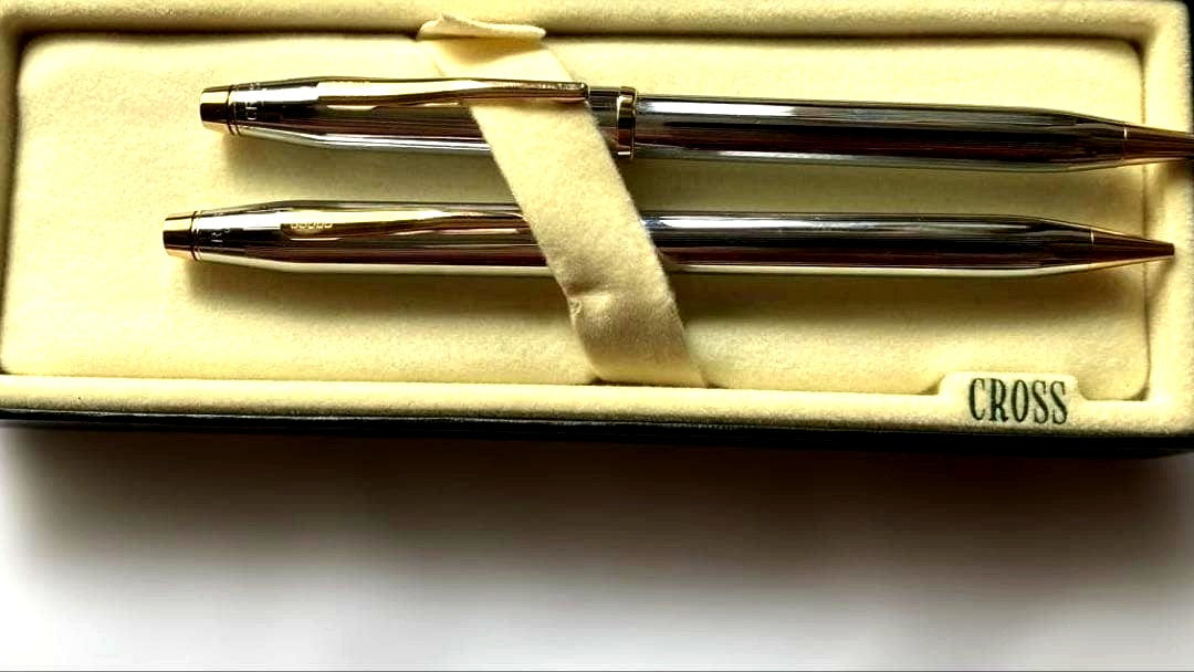 Cross ballpoint pen and mechanical pencil set with sleek silver finish on white background