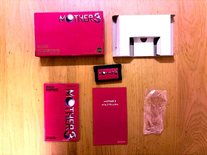 MOTHER3 Game Boy Advance game with outer box, inner box, and instruction manual showing slight box tears