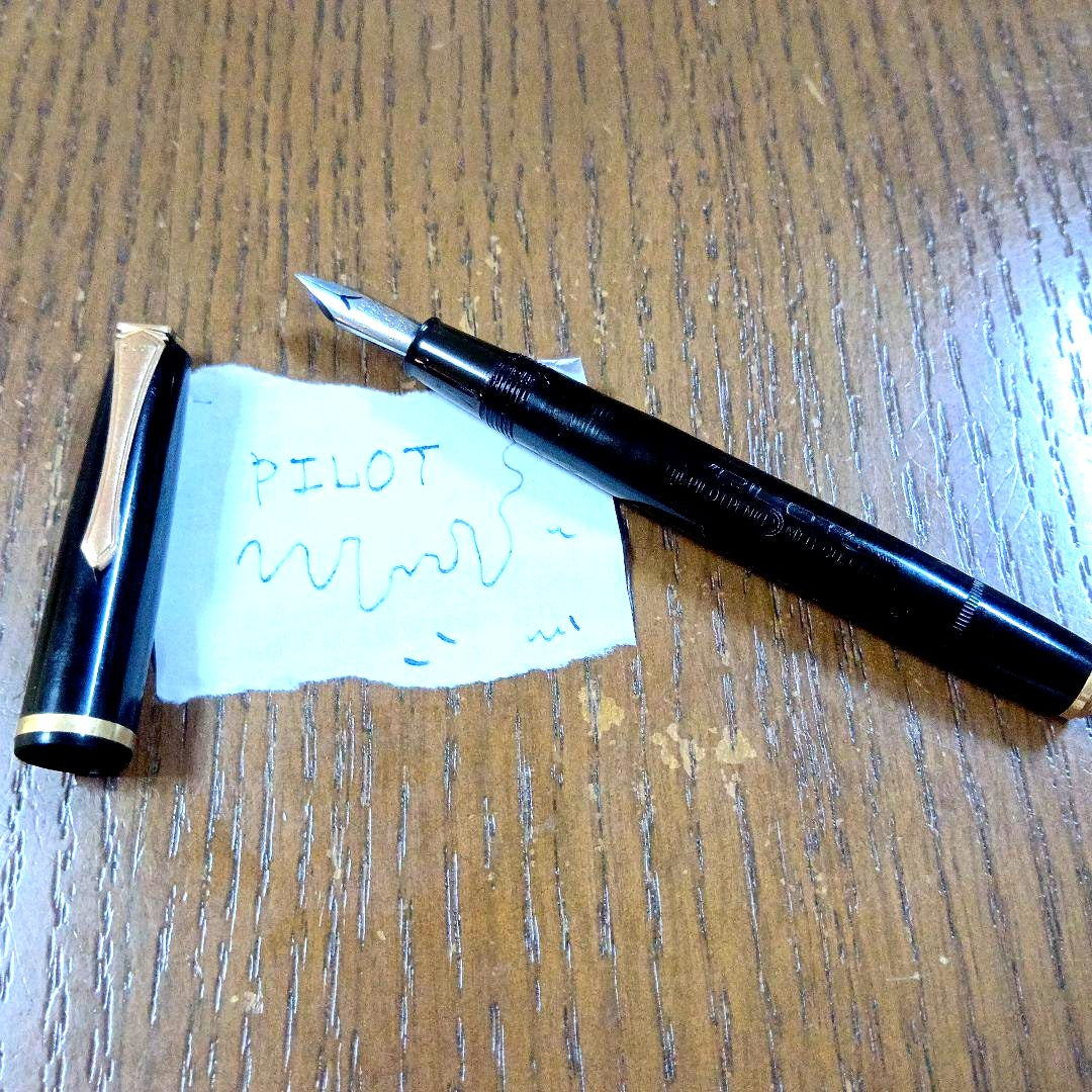 Vintage Pilot Plunger Fountain Pen with steel nib and slightly open clip on white background