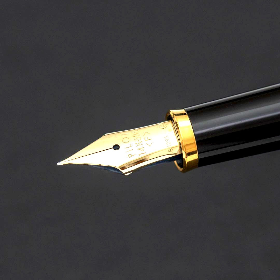 Pilot fountain pen with 14k gold fine nib, black and gold body, and blue-black ink cartridge included