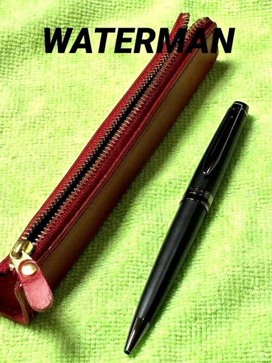 Red leather pencil case measuring 14 cm with a black Waterman pen set displayed together