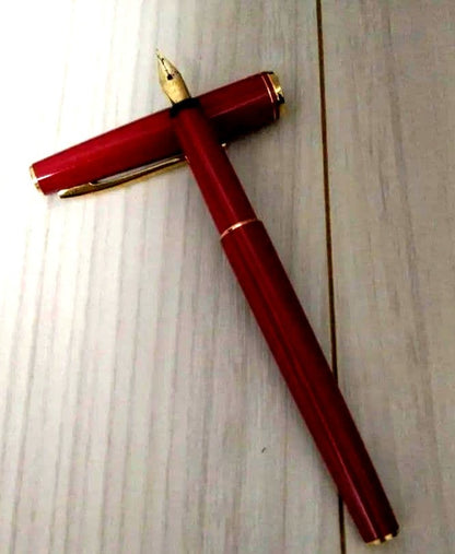 Red Pilot fountain pen with gold trim and fine tip, cartridge type, shown on white background