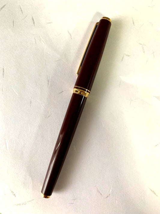 PILOT DELUXE fountain pen in Bordeaux with 14K fine nib shown from side on white background