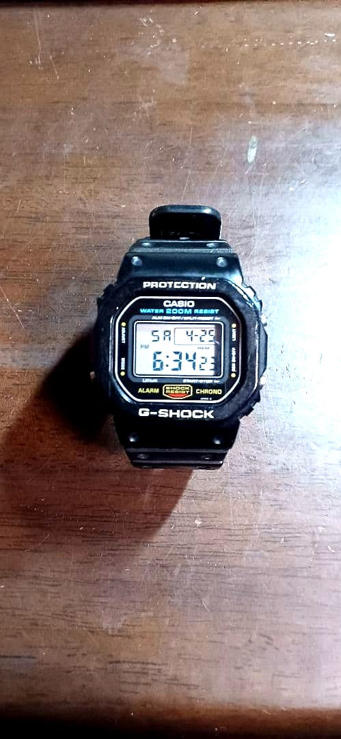 Casio G-Shock 901 DW5600 black watch with green light and resin bezel showing signs of wear