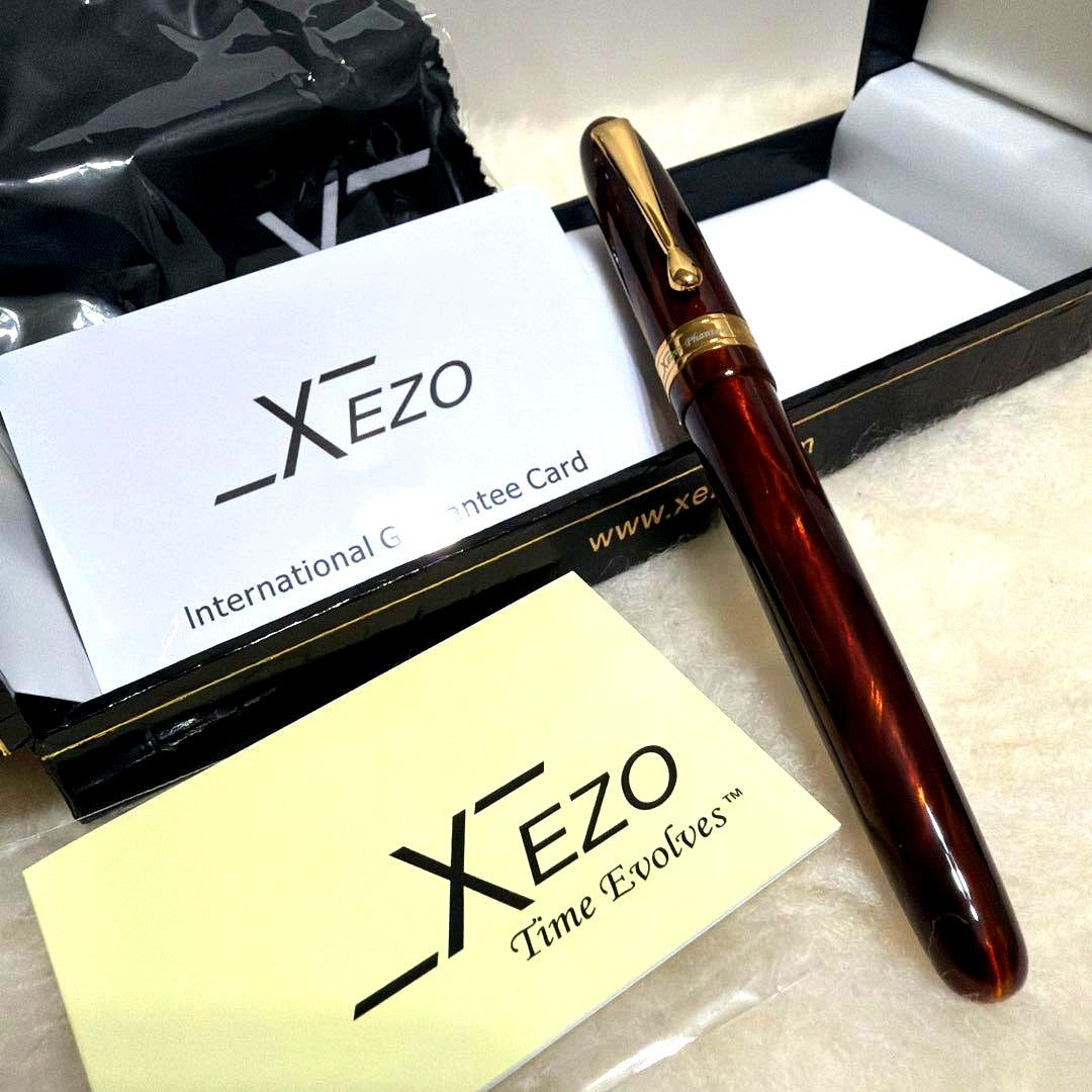 Xezo Handmade fountain pen body in reddish brown with gold accents, displayed with gift box, cross, and guarantee card