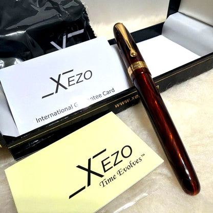 Xezo Handmade fountain pen body in reddish brown with gold accents, displayed with gift box, cross, and guarantee card