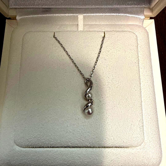 Mikimoto pearl necklace made of 18K white gold displayed on a white background
