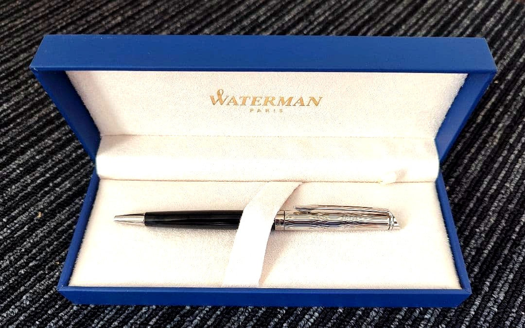 WATERMAN Paris ballpoint pen with silver wave pattern cap and black body beside a blue gift box