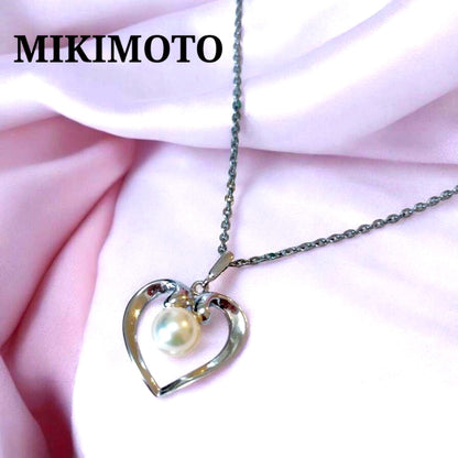 Mikimoto pearl necklace with silver heart pendant and 37 cm Akoya pearls on white background