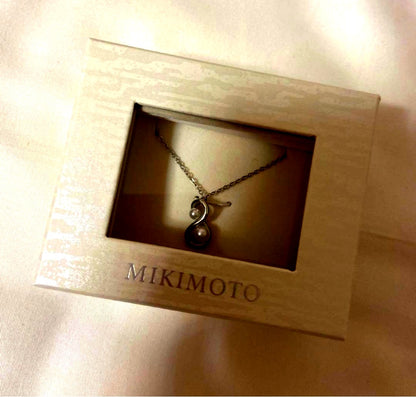 Mikimoto pearl necklace featuring a silver pendant displayed with its box