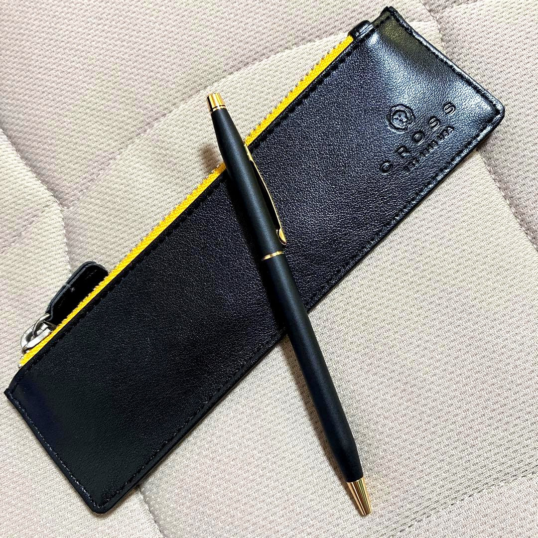 Cross ballpoint pen with matte black body and gold accents displayed with yellow interior case