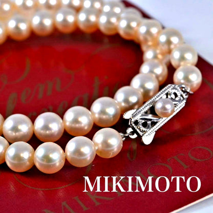 Highest-grade Mikimoto K14 Akoya pearl necklace with 7mm round pearls and white gold clasp on a white background