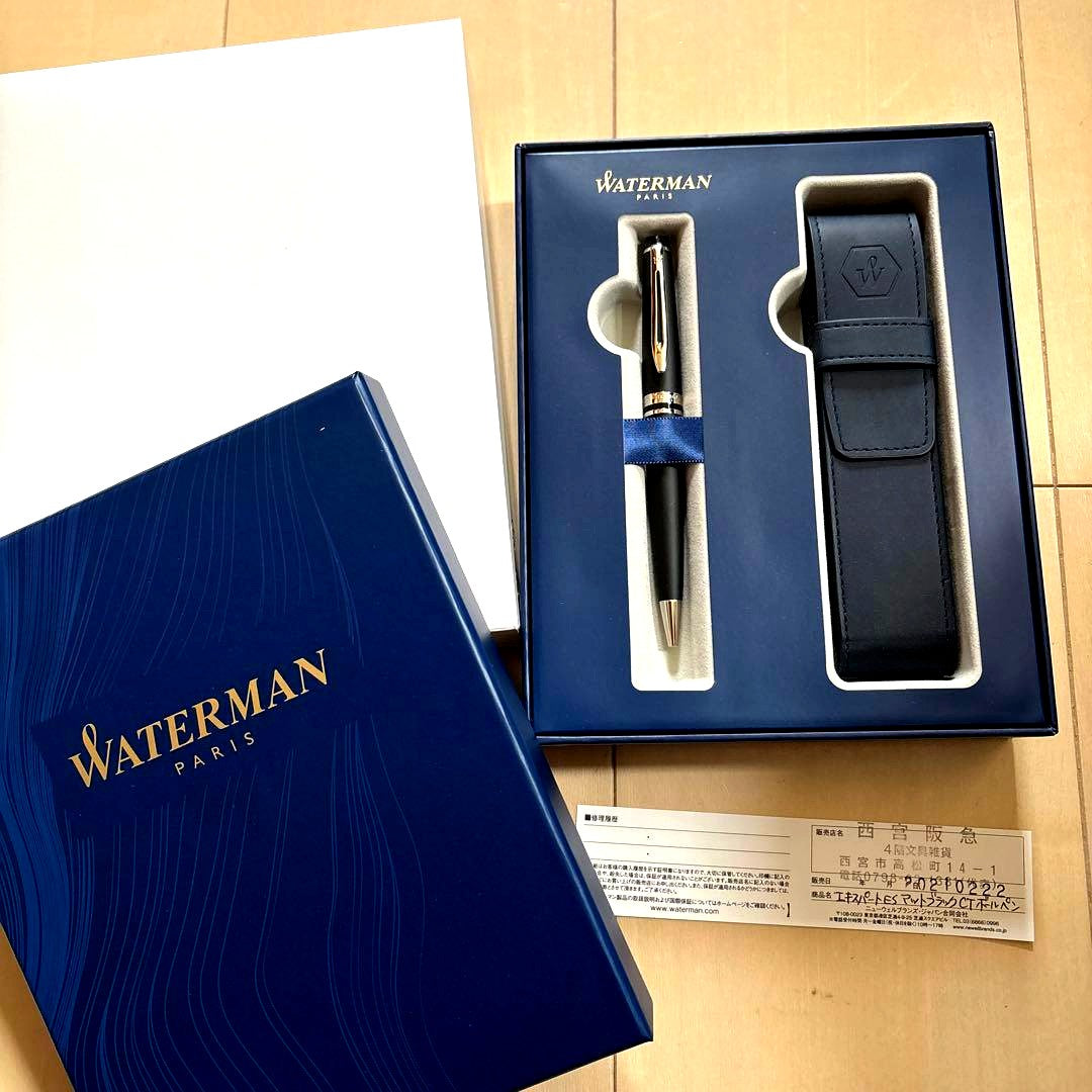 WATERMAN black ballpoint pen alongside its leather case and gift box on a white background