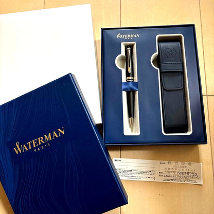 WATERMAN black ballpoint pen alongside its leather case and gift box on a white background