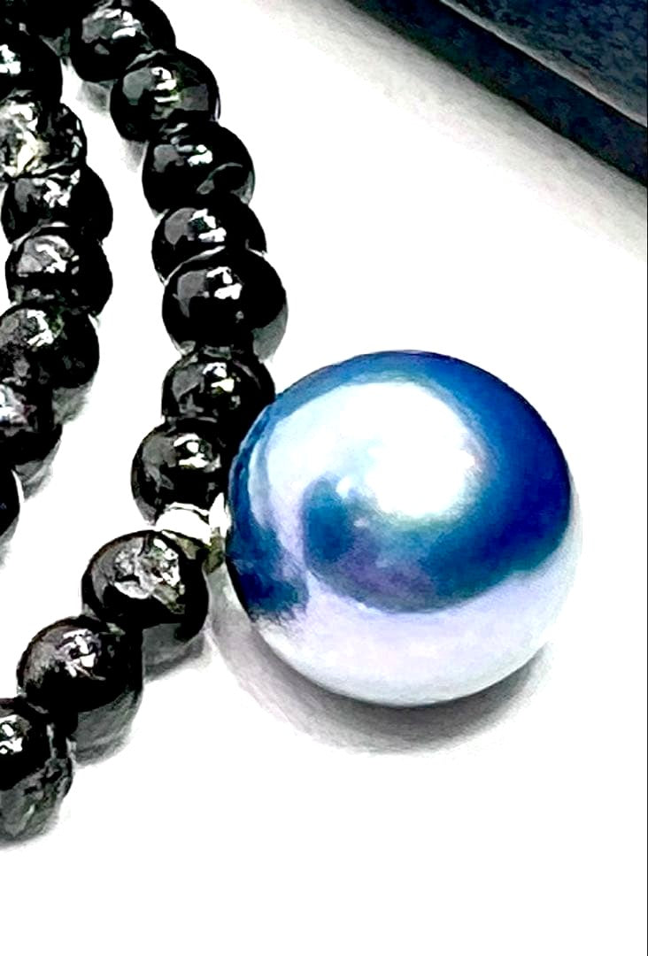 Oomamemono Akoya pearl black tourmaline necklace with round indigo blue pearls on white background