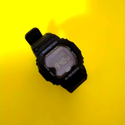 Casio G-Shock GW-5600BJ digital watch with black resin band and square face showing radio signal and tough solar features
