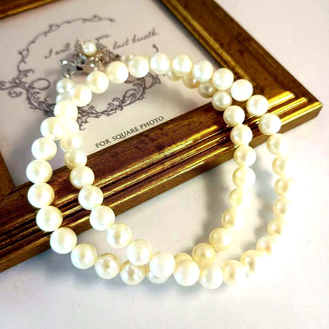 Single-strand Akoya pearl necklace with silver flower motif clasp, creamy white pearls approximately 6.5-6.7 mm diameter