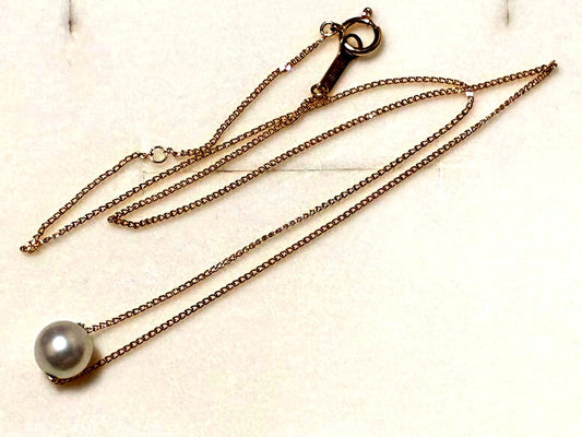 Tasaki K18 Pearl Necklace featuring lustrous pearls and 18 karat gold chain with brand markings