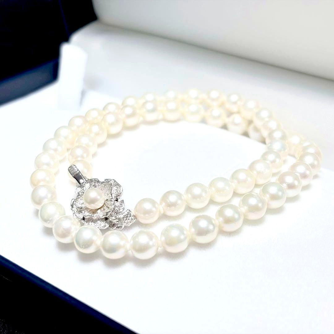 Akoya genuine pearl necklace with 6.4-6.9mm white pearls and silver SV clasp laid out on a white background