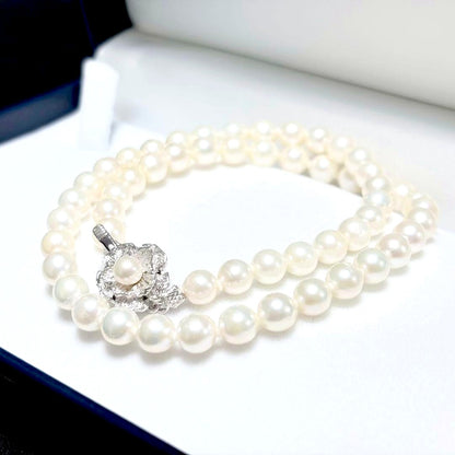 Akoya genuine pearl necklace with 6.4-6.9mm white pearls and silver SV clasp laid out on a white background