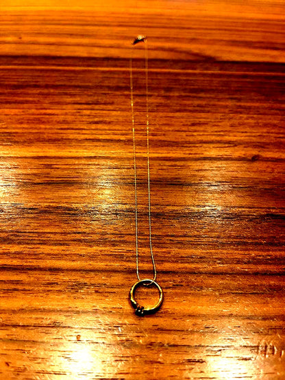 Mikimoto gold necklace with a sapphire pendant displayed on a white background