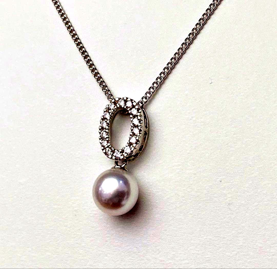 Akoya pearl pendant necklace with 7mm pearl, cubic zirconia accents, and silver 925 rhodium plated chain on white background