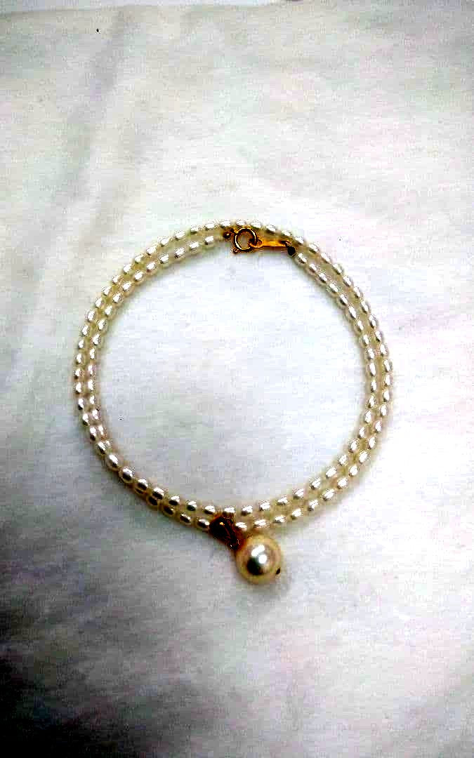 Freshwater Akoya pearl necklace with single 9mm pearl and 18K gold clasp on white background
