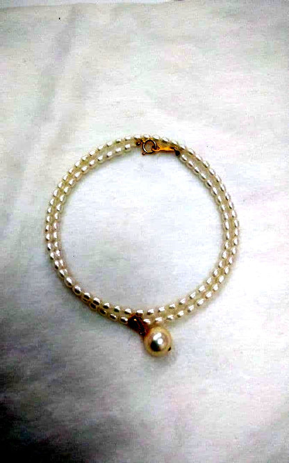 Freshwater Akoya pearl necklace with single 9mm pearl and 18K gold clasp on white background
