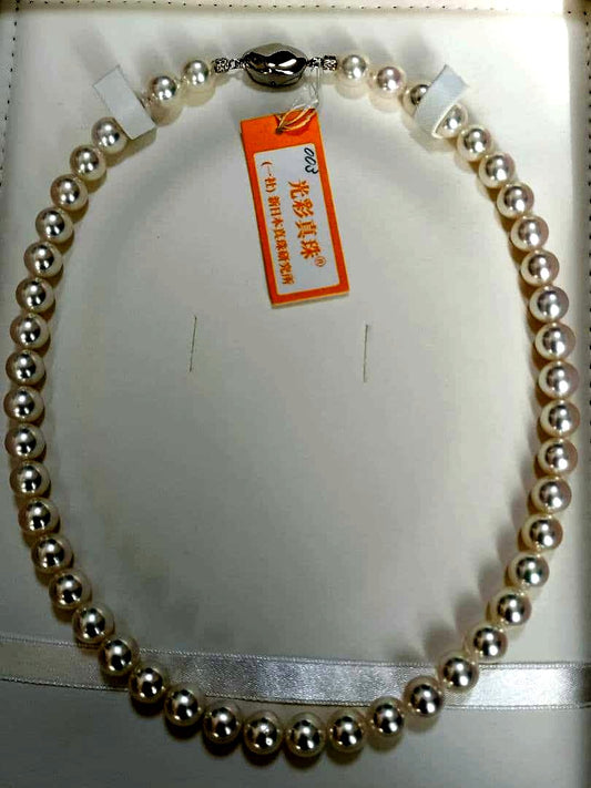 Akoya pearl large round necklace with white pearls and pink-green light interference on a white background