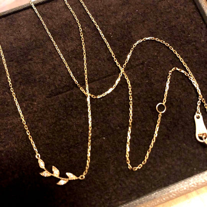 Close-up of agate Laurel Leaf K10 necklace featuring small diamonds on a shiny gold chain