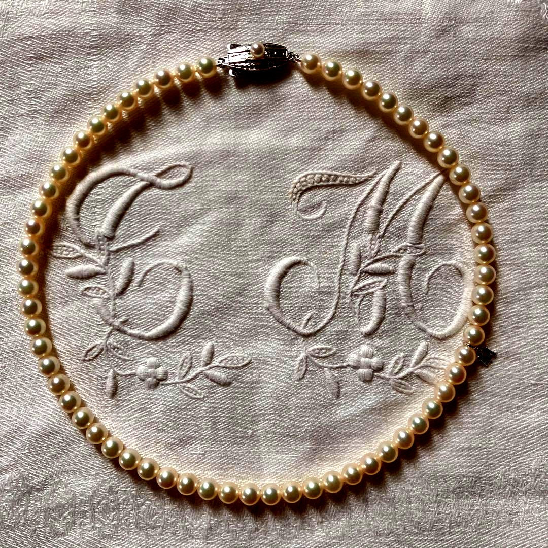 MIKIMOTO pearl choker necklace with 63 round pearls and silver M engraved clasp displayed with original box