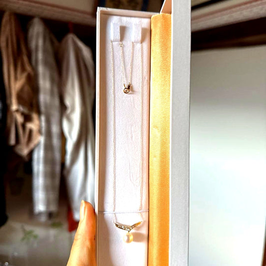 18k gold necklace with 0.2ct diamond and 8.5mm Akoya pearl on a white background