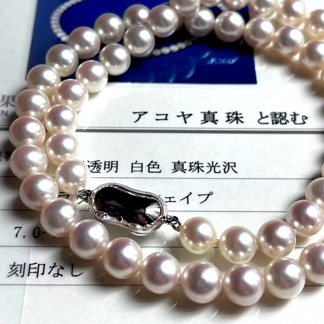 Close-up of Akoya pearl necklace with white pearls showing pink and green interference colors and silver clasp