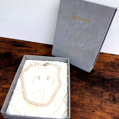 Tasaki pearl necklace and matching earrings displayed with the included case